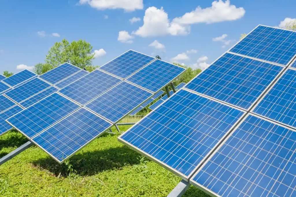 frei stehende Photovoltaik Anlagen auf Feld mit blauem Himmel und Wolken im Hintergrund
